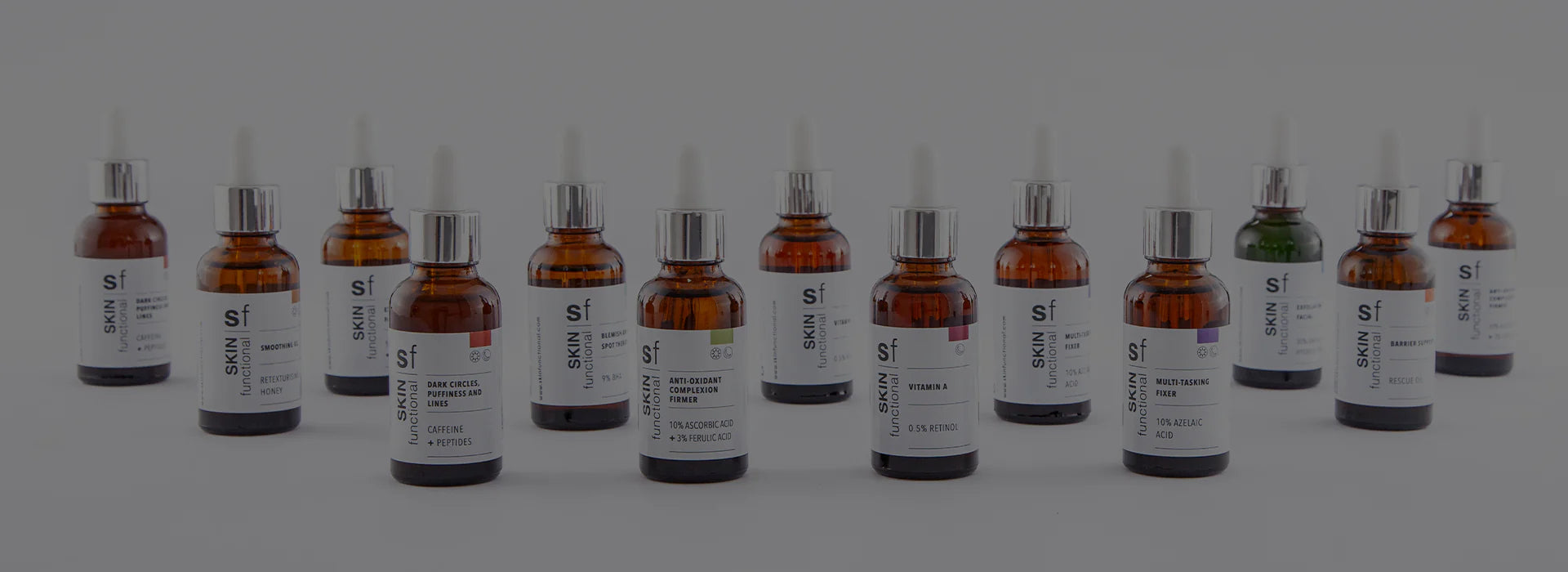 Row of various bottles with droppers on a gray background