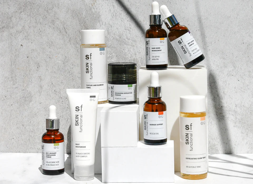 Collection of skincare products from Skin Functional on a gray background