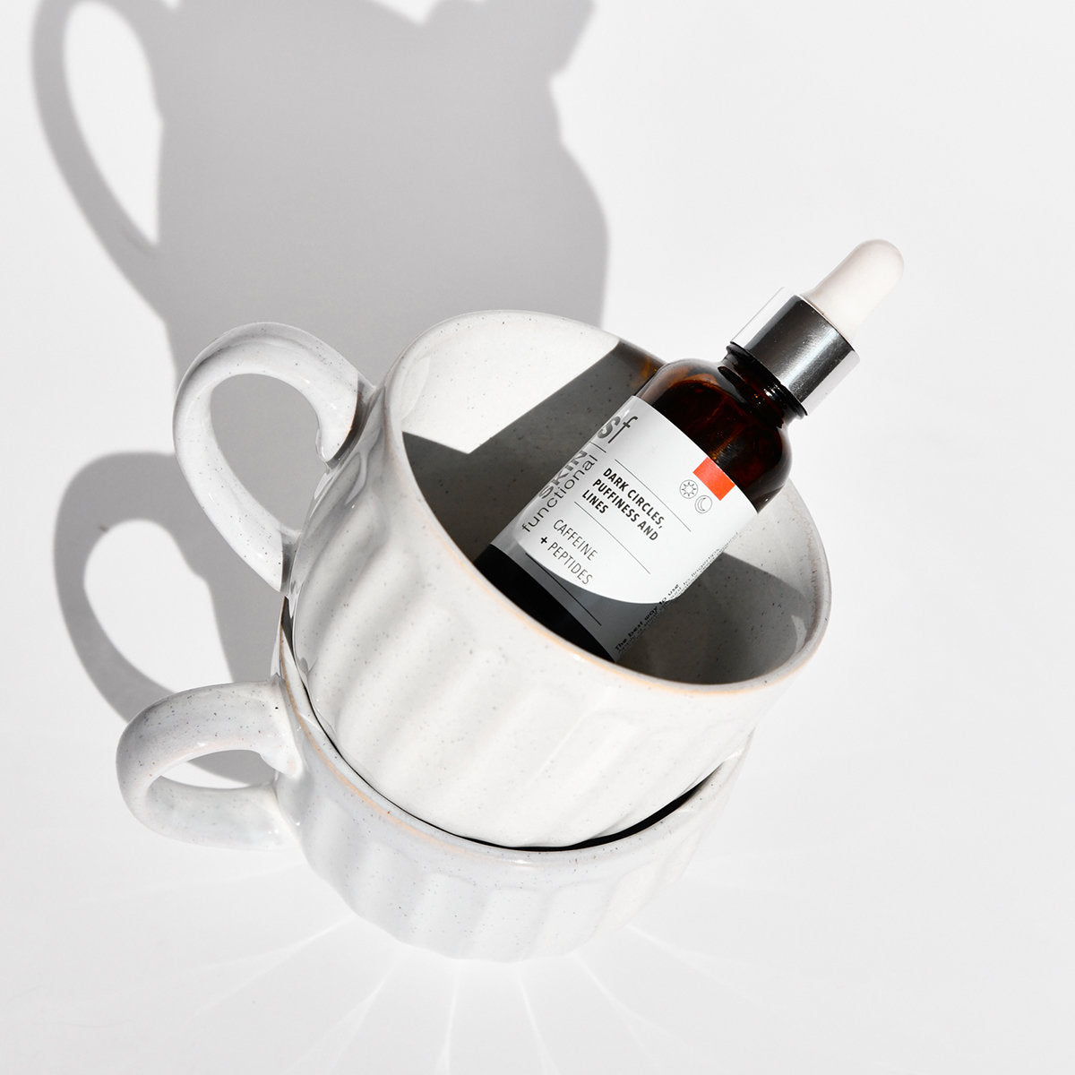 SKIN Functional dark circles, puffiness and lines treatment with details skincare product on a grey background