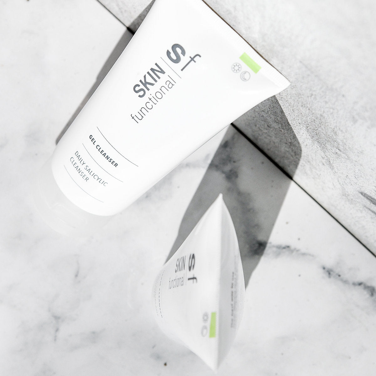 SKIN Functional Salicylic Cleansing Complex Gel Cleanser with details skincare product on a grey background