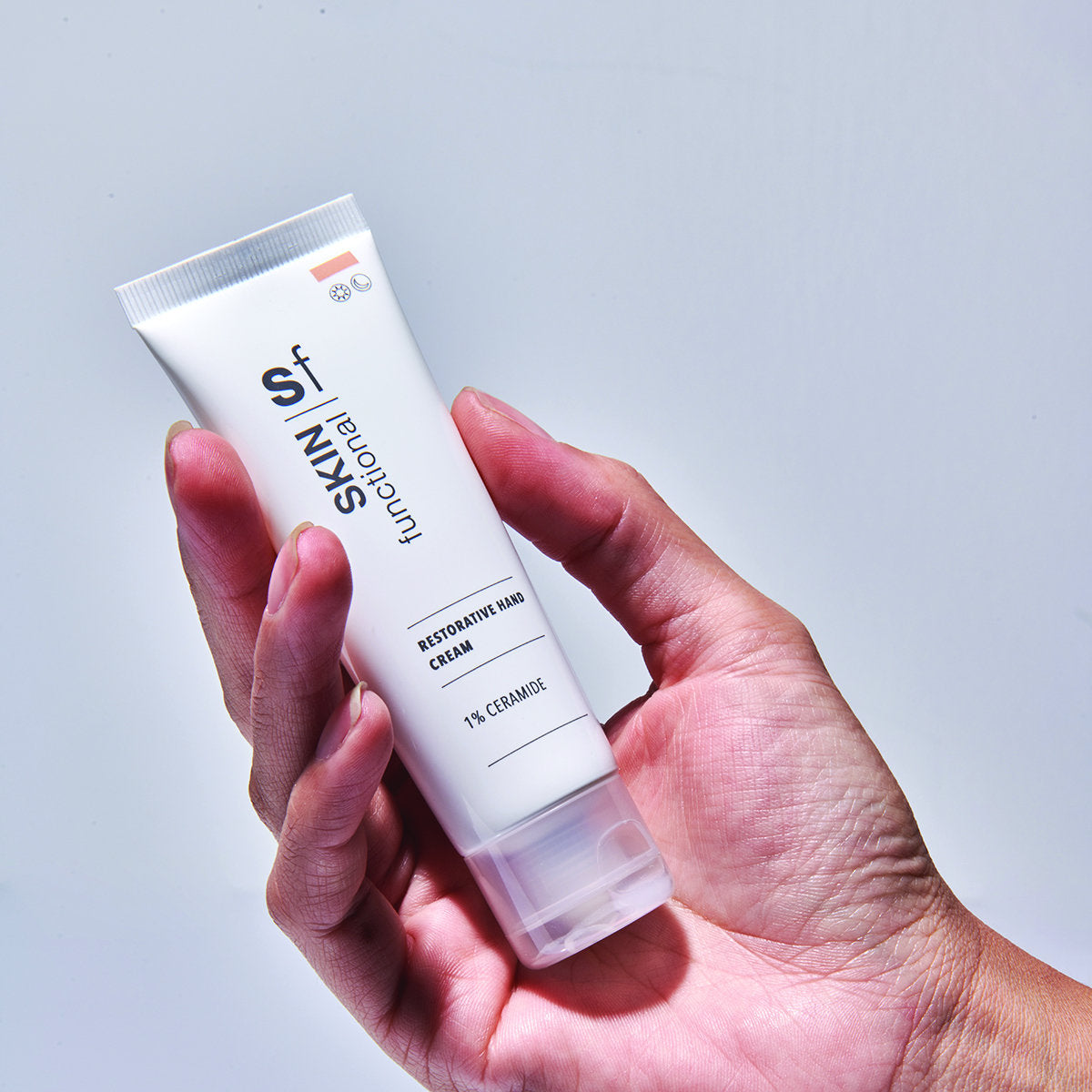 SKIN Functional Restorative Hand Cream with details skincare product on a light gray background