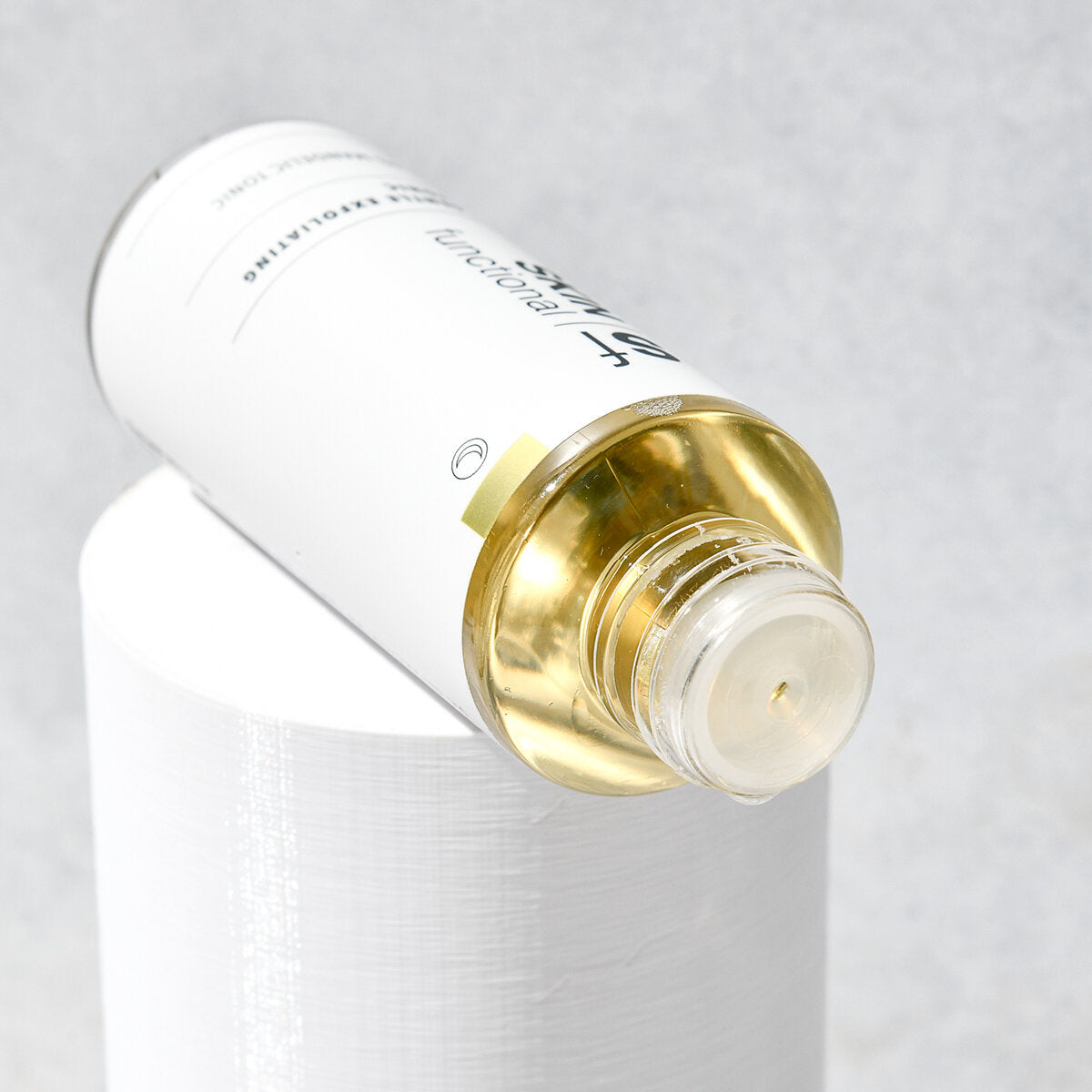 SKIN Functional gentle exfoliating tonic with details skincare product on a grey background