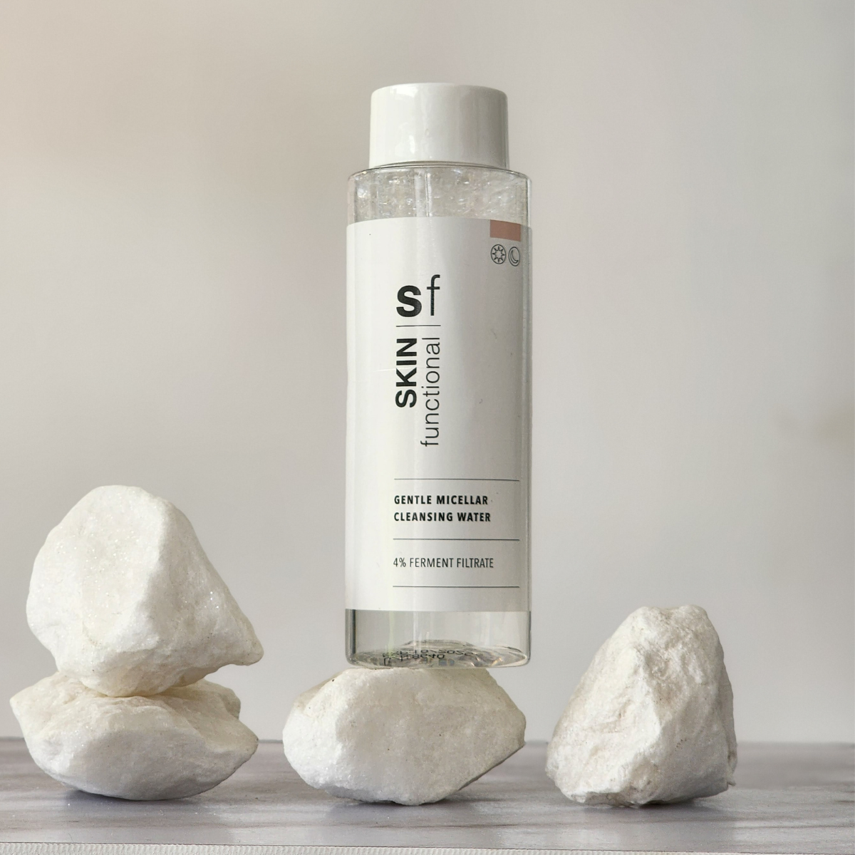 Bottle of Skin Functional Gentle Micellar Cleansing Water with rocks on a neutral background