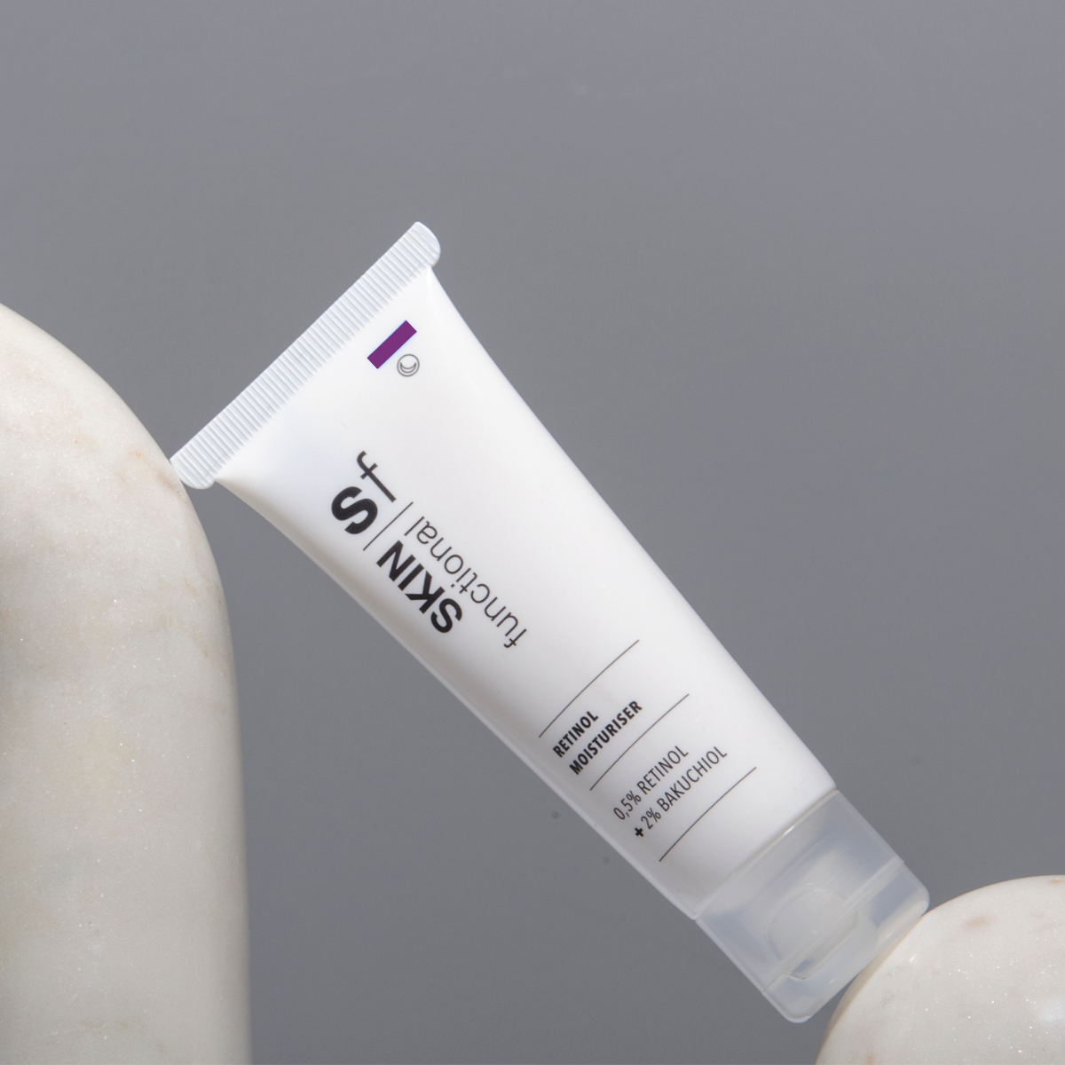 SKIN Functional Retinol Moisturiser with details skincare product on a light gray background
